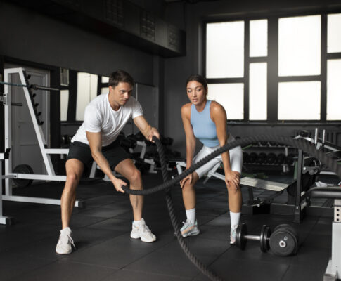 Pemula sedang melakukan latihan fitness di gym modern dengan peralatan dumbbell dan treadmill