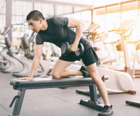 Pria dan wanita berolahraga di gym dengan fokus latihan konsisten untuk hasil maksimal